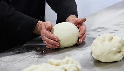 Foto van deeg dat wordt gekneden voor worstenbrood